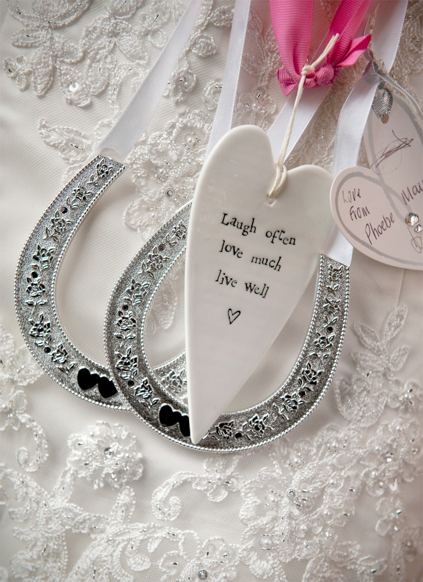 lucky horshoe charms in front of bridal gown, wedding photographers in south wales.